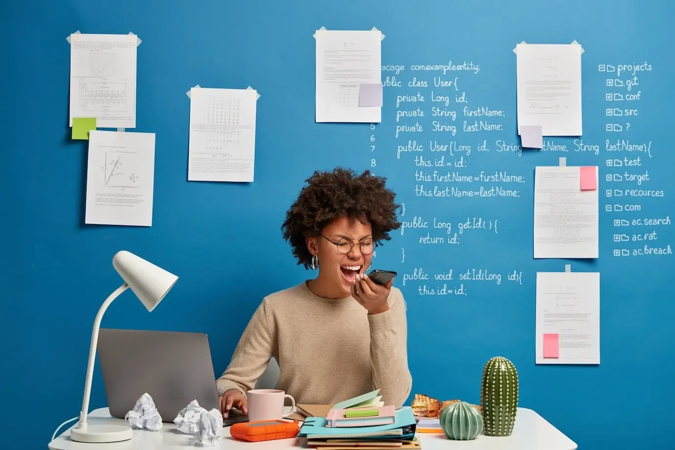 Wütender Student oder Freiberufler schreit wütend während eines Telefonats, sitzt vor einem Laptop, hat ein nerviges Gespräch mit einem Kunden und entwickelt eine Plattform für eine Website.