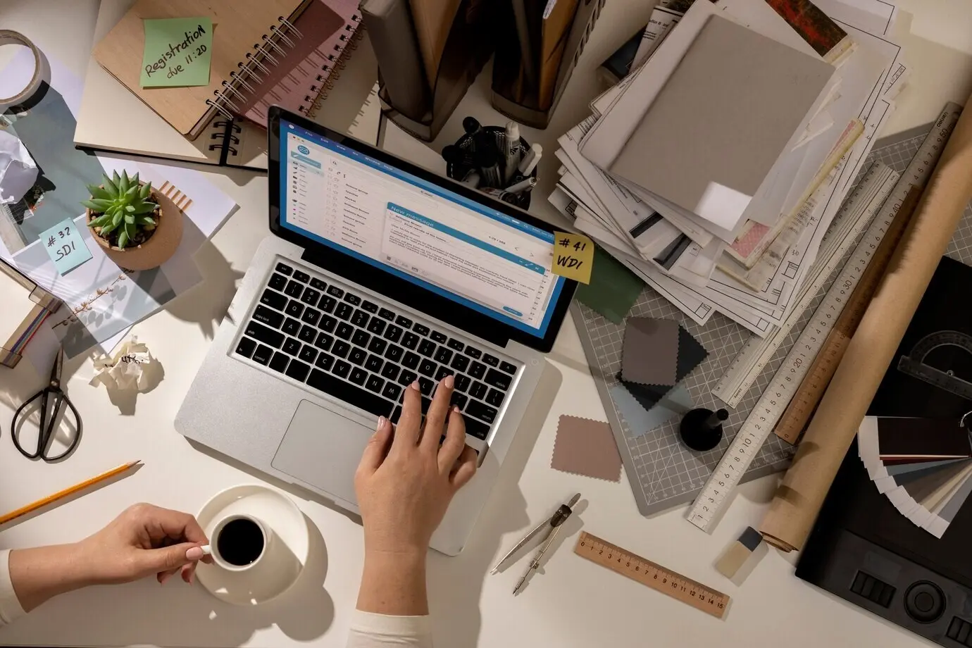 Blick auf einen unaufgeräumten Büroarbeitsplatz mit einem Laptop.